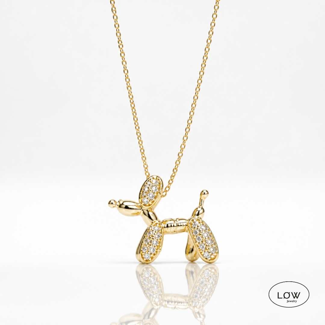 Lumi Balloon Dog Necklace Gold fra LØW Jewelry er et gullfarget halskjede med ballonghund og glitrende zircon. 40 + 5 cm.
