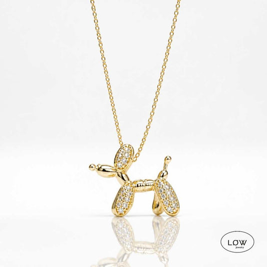 Lumi Balloon Dog Necklace Gold fra LØW Jewelry er et gullfarget halskjede med ballonghund og glitrende zircon. 40 + 5 cm.