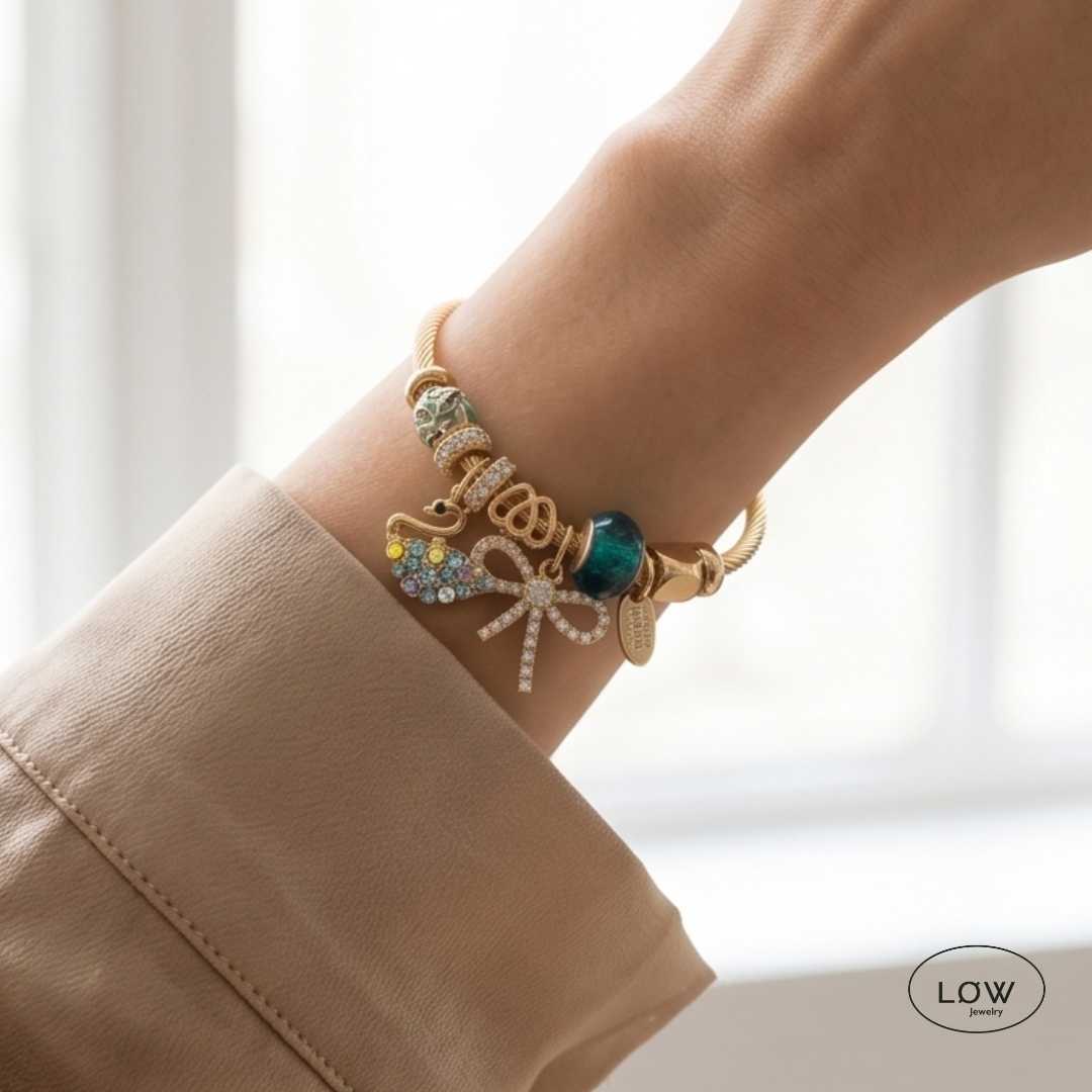 Swan &amp; Bow Charm Bracelet Gold fra LØW Jewelry ferdig fylt charms armbånd