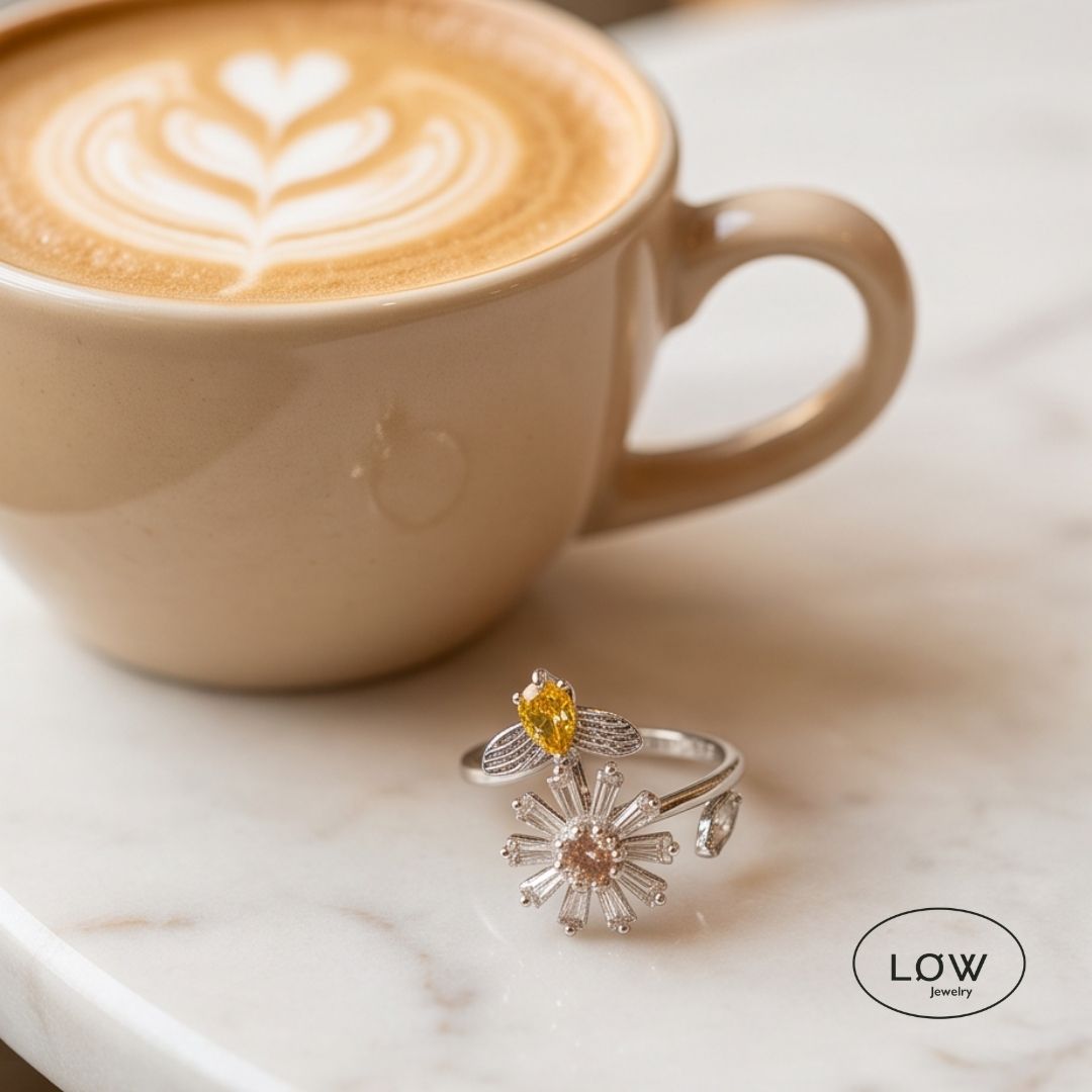 Sølvfarget justerbar fidget ring i kobber med roterende blomst og bie. Velg blå eller rosa blomsterkjerne. Fra LØW Jewelry.